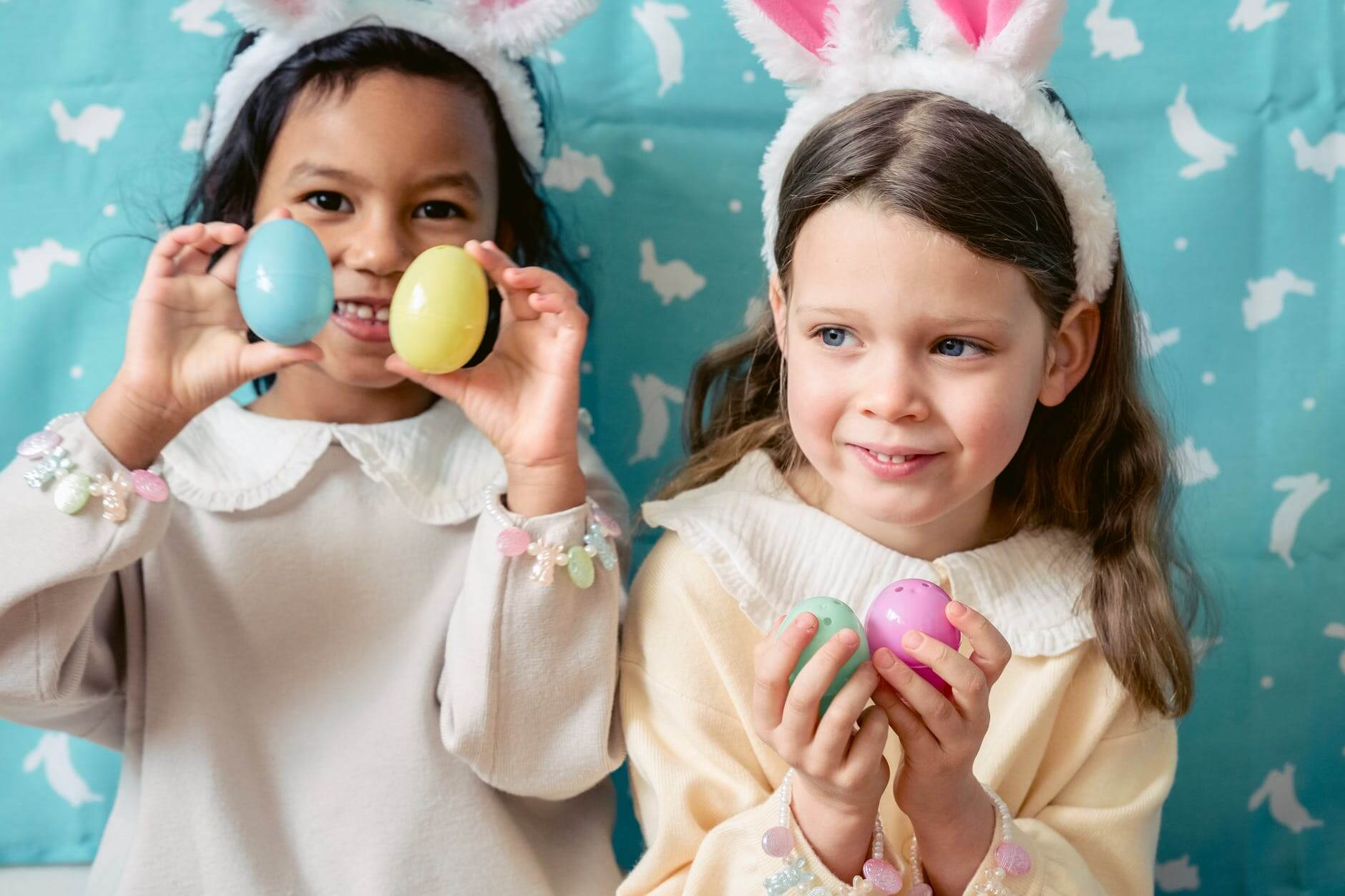 glad diverse girls playing with toy eggs